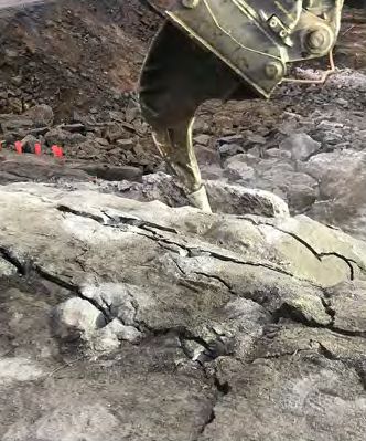 Cazo de excavadora retirando la roca partida